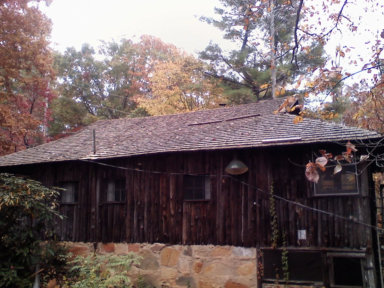Weathered wood shake roof on a rustic board sided cabin in Valatie