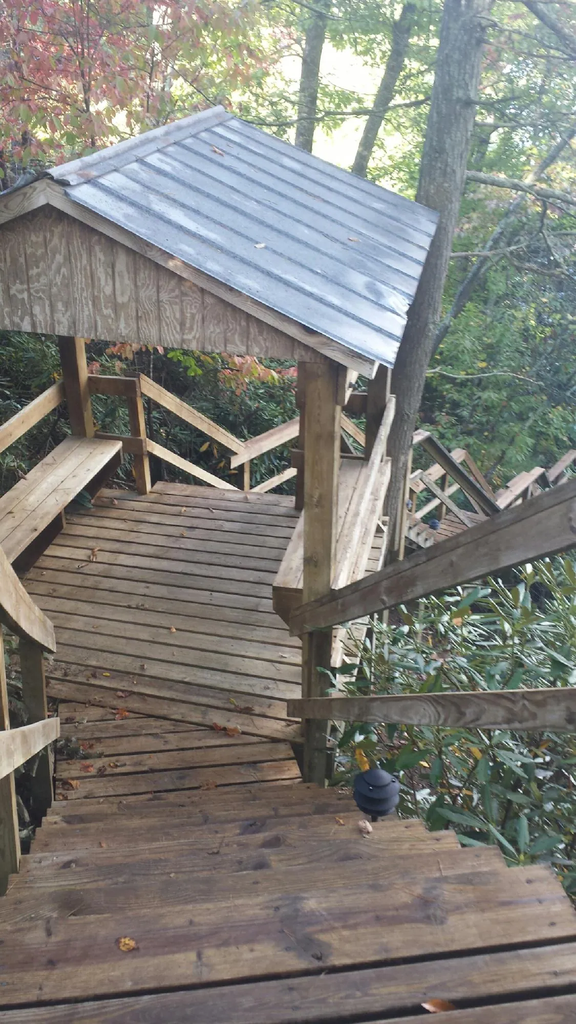 Metal roofed shelter over wooden steps on a wooded walkway — Skylight Repair & Installation work by our crew in Valatie