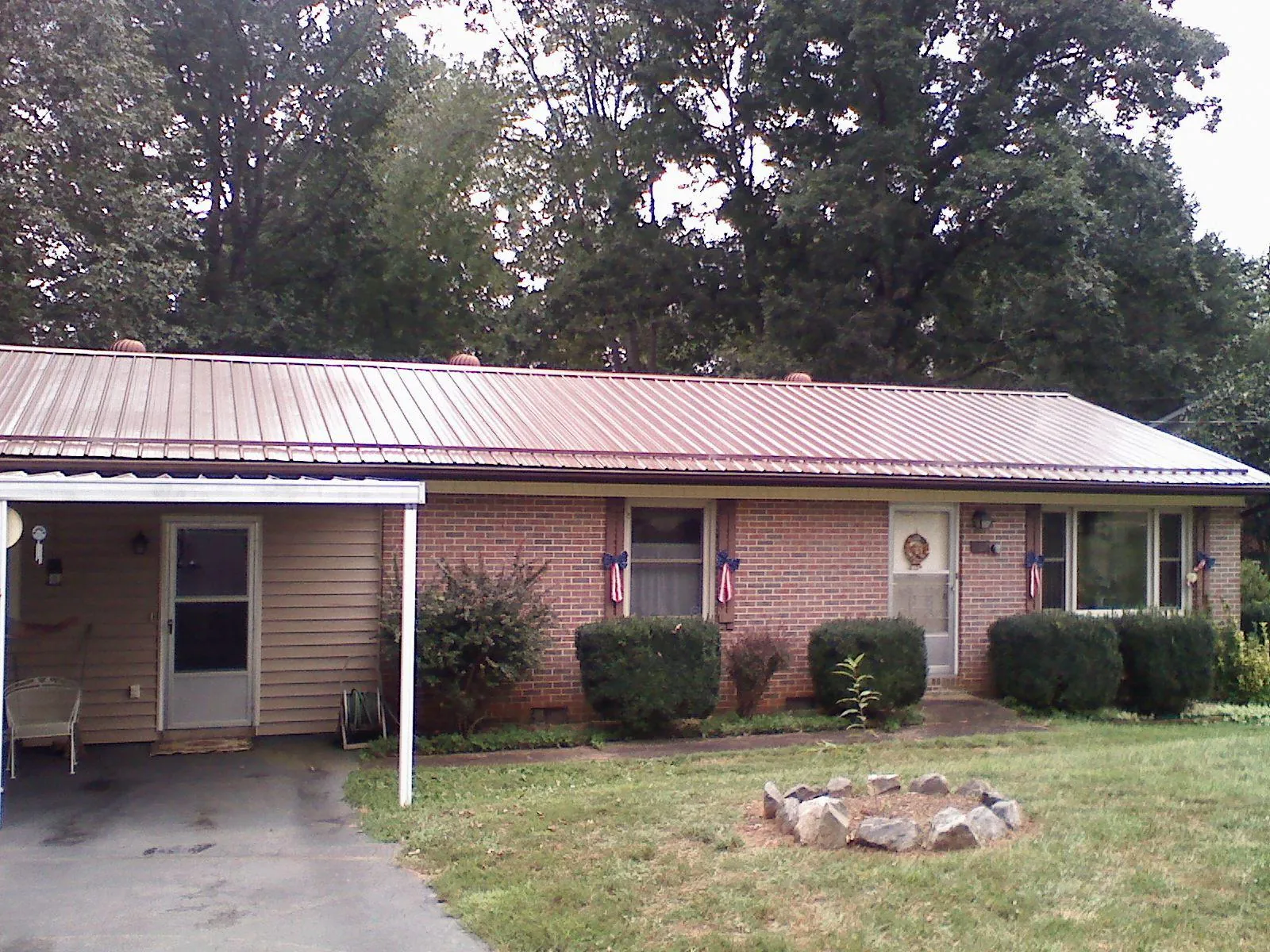 Bronze metal roof and carport on a brick ranch home — Roof Repair work by our crew in Valatie